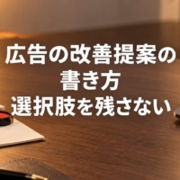 提案書とスタンプが置かれた机とノートパソコン